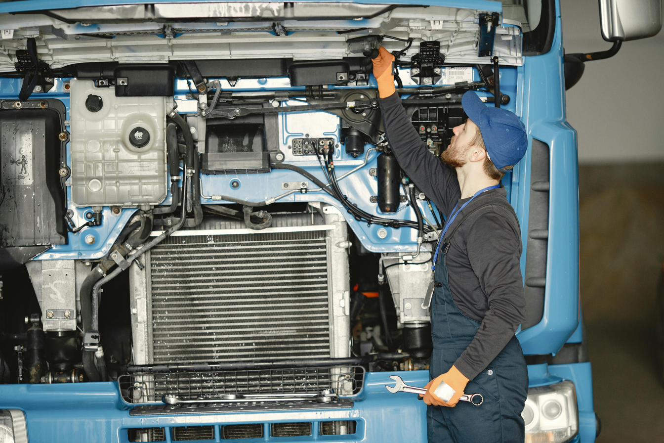 Fleet mechanic inspecting engine bay of a large commercial truck
