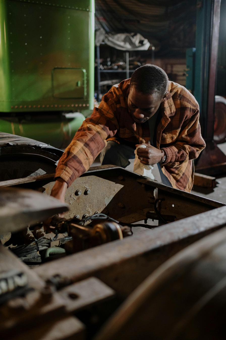 Public works maintenance technician working on heavy equipment in a municipal yard
