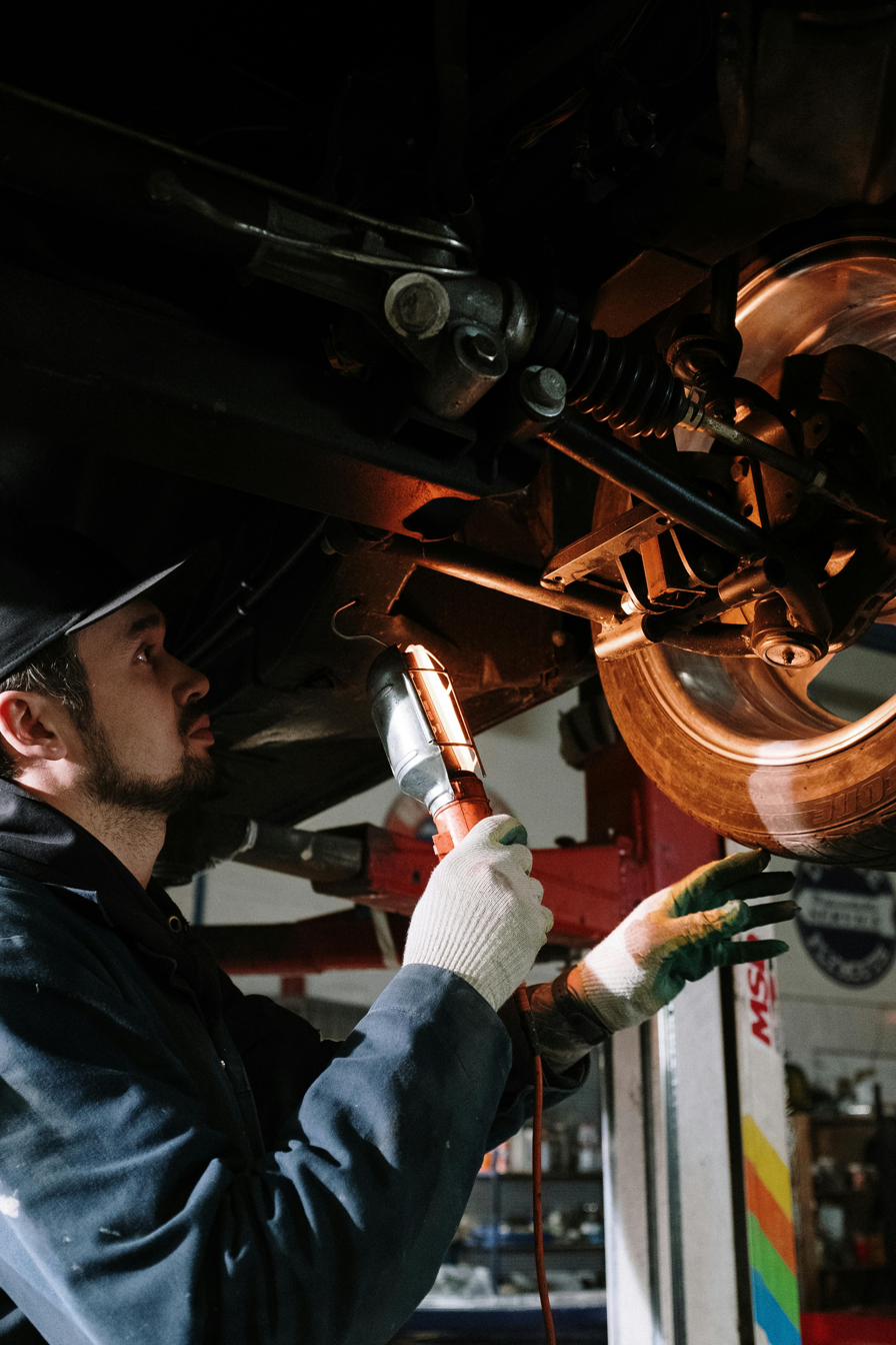 New fleet maintenance technician working under a vehicle on a lift