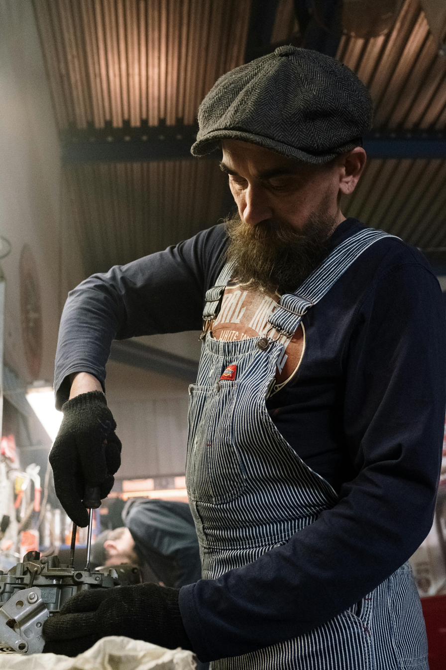 Veteran diesel mechanic working on an engine in a fleet maintenance shop